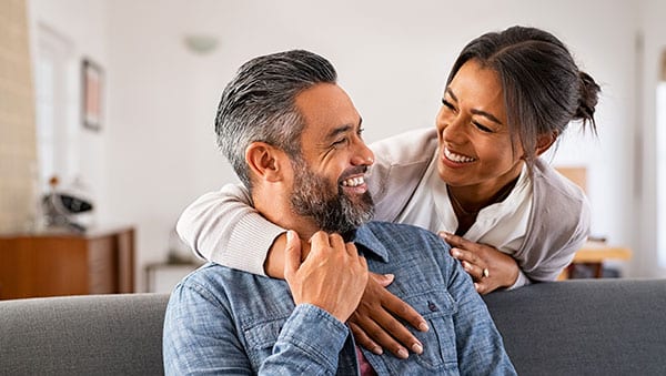 Birth Control Mature multiethnic couple laughing and embracing at home